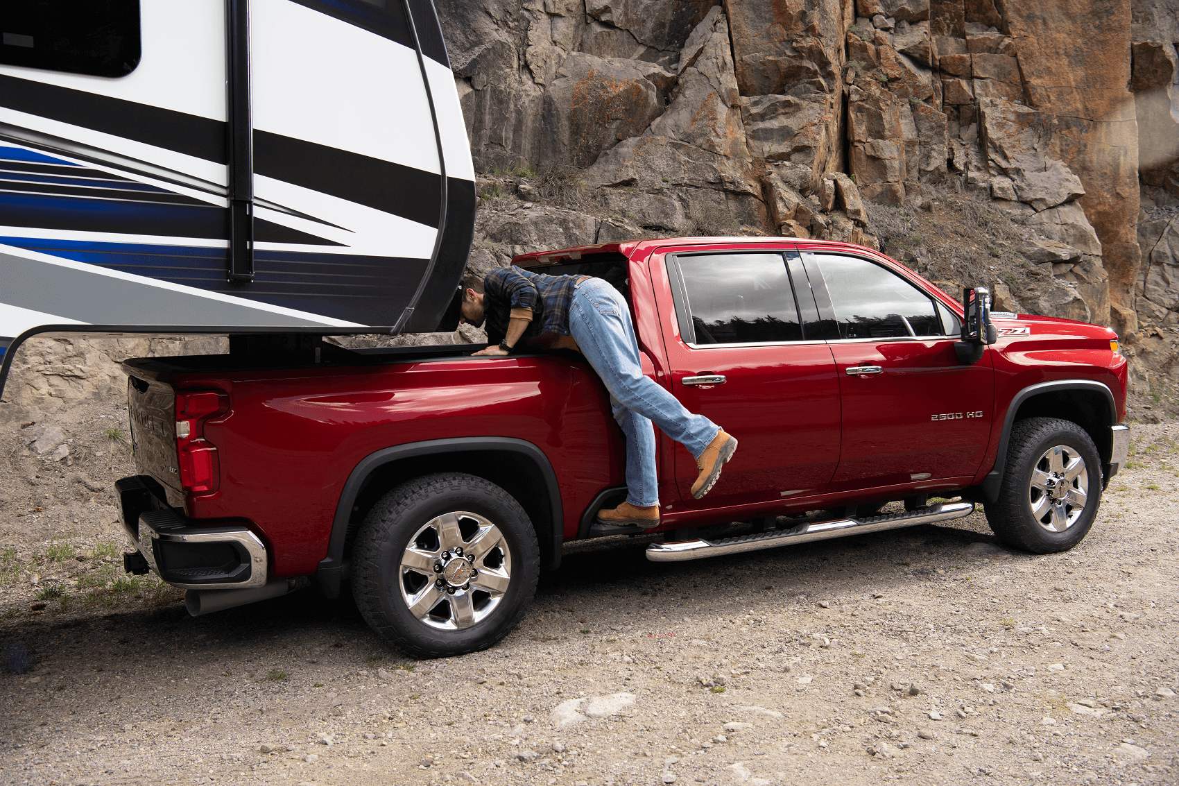 A red Chevy Silverado 2500 tows a large camper